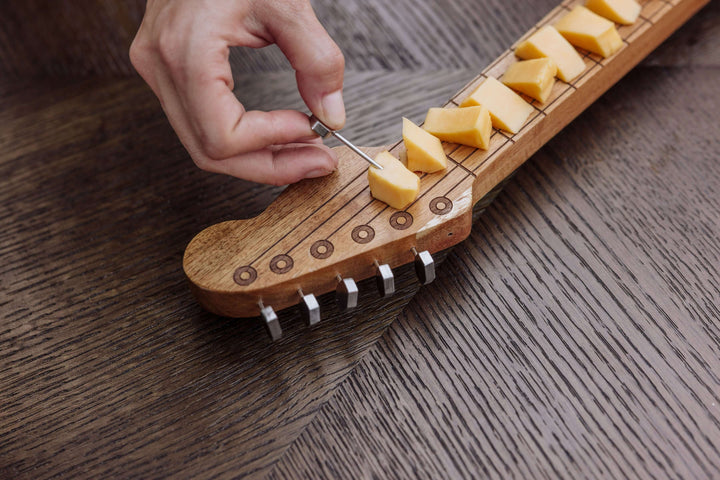 Vintage Guitar-Shaped Cheese Board with Hidden Drawer and Tools featuring sliced cheese