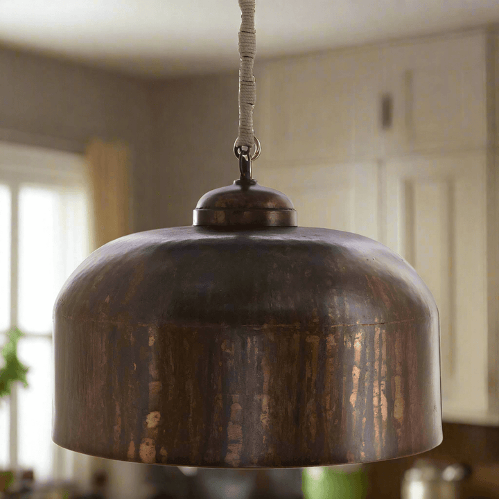 Vintage industrial iron pendant light with jute wrap in a modern kitchen setting.