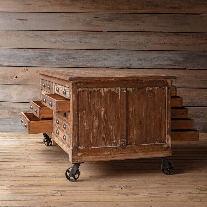 Vintage Industrial Rolling Workbench with Drawers made from reclaimed wood with aged finish and metal wheels.