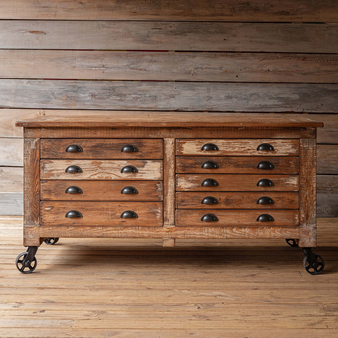 Vintage Industrial Rolling Workbench with Drawers made from reclaimed wood with rustic finish against wooden background.
