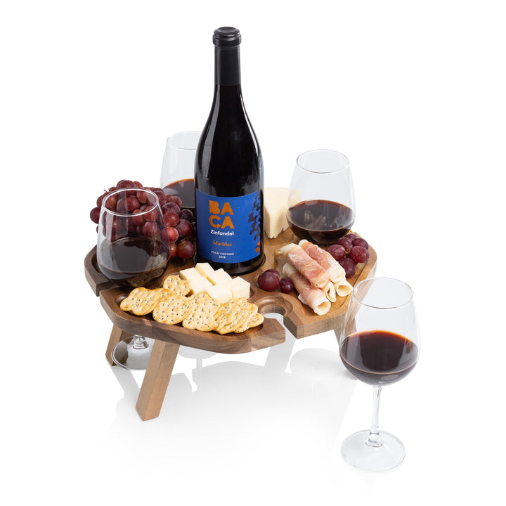 Vintage-Inspired Wine Picnic Table with wine, cheese, and glasses on acacia wood with folding legs for outdoor entertaining.