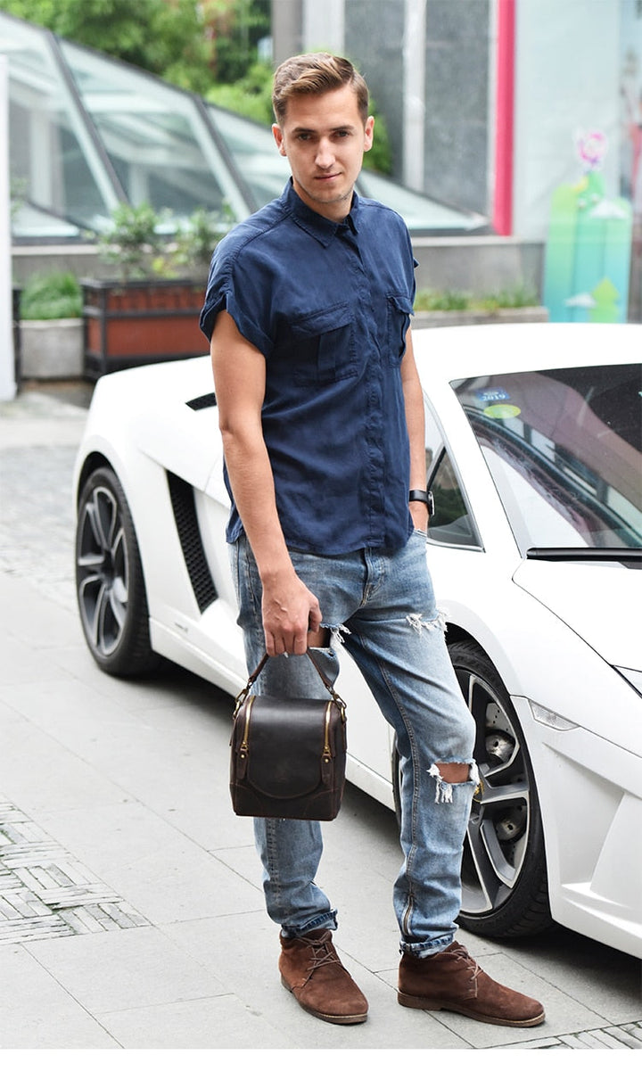 Man holding Vintage Full-Grain Leather Camera Bag next to a luxury car