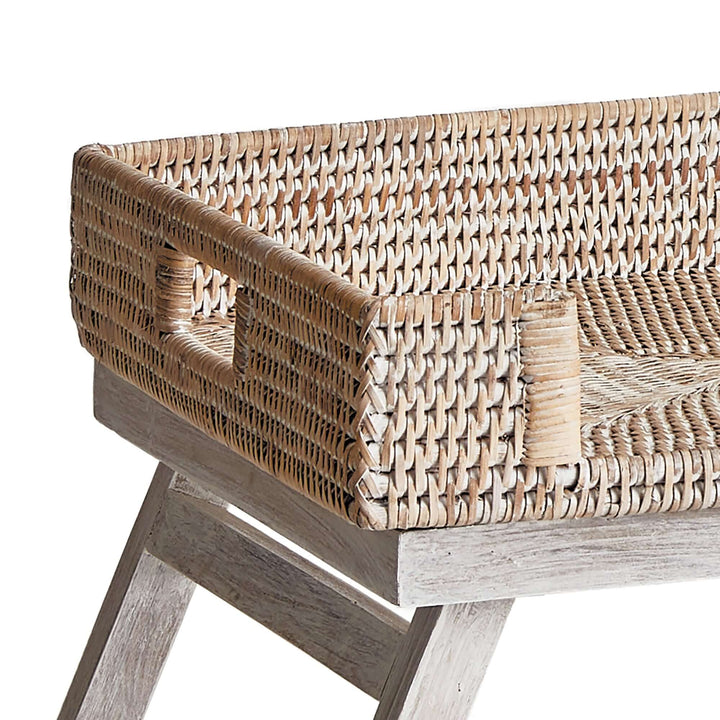 Close-up of vintage rattan tray table showcasing intricate weave and collapsible legs for a charming decor.