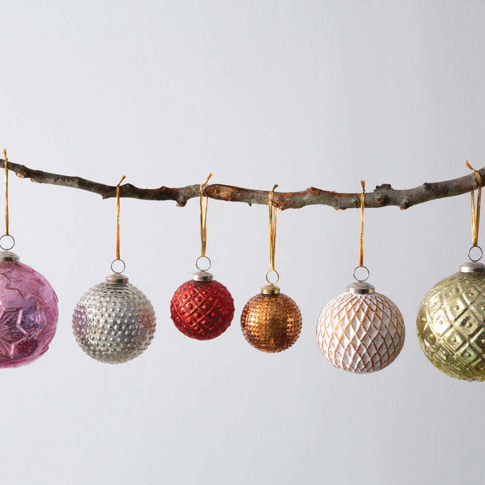 Vintage Red Mercury Glass Christmas Ornament (Set of 4) hanging on a branch alongside assorted holiday ornaments.