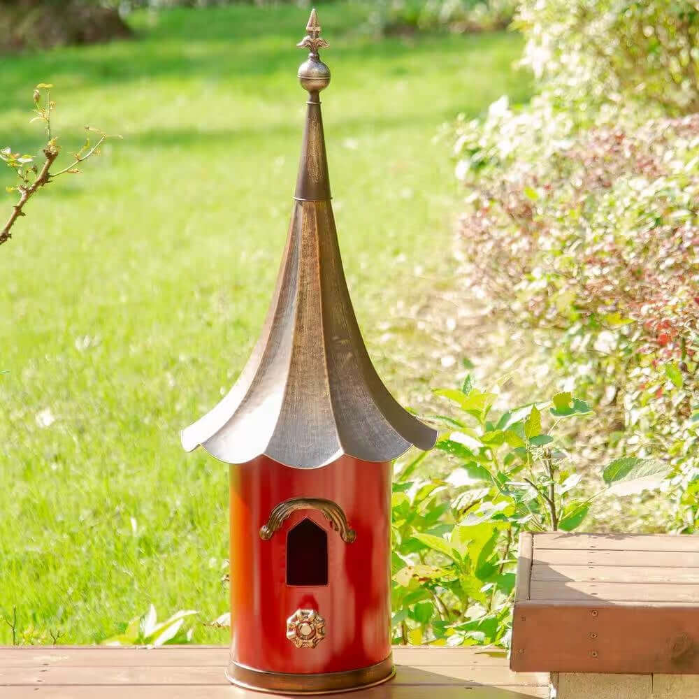 Vintage Red Metal Birdhouse with Bronze Pagoda Roof in garden setting