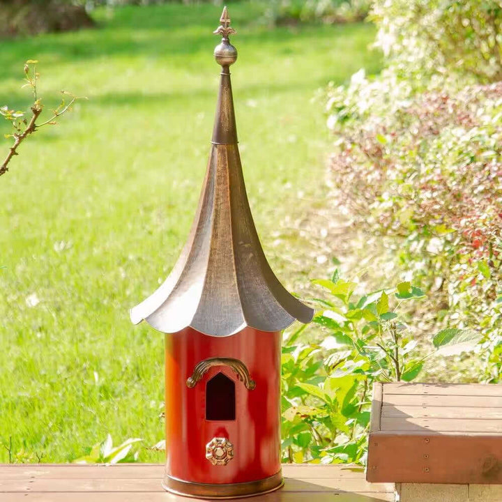 Vintage Red Metal Birdhouse with Bronze Pagoda Roof in garden setting