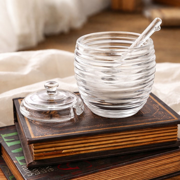 Clear ribbed honey jar and fitted lid shown in warm natural light