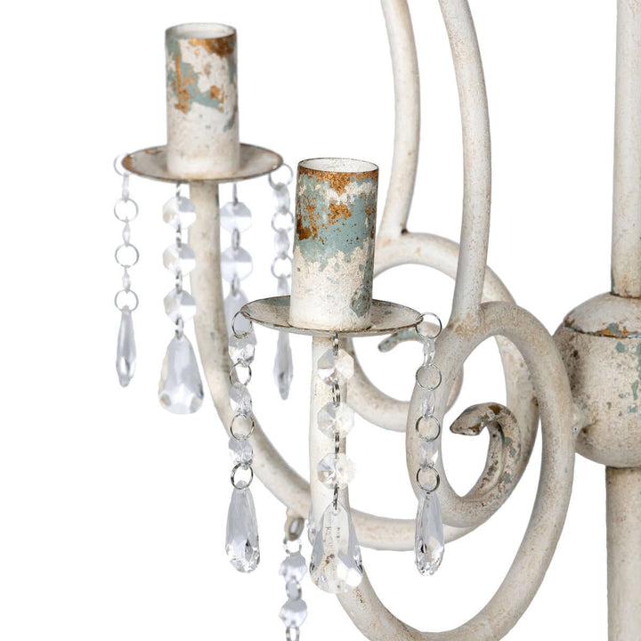 Close-up of vintage tabletop chandelier with distressed finish and crystal accents, showcasing rustic charm and elegance.