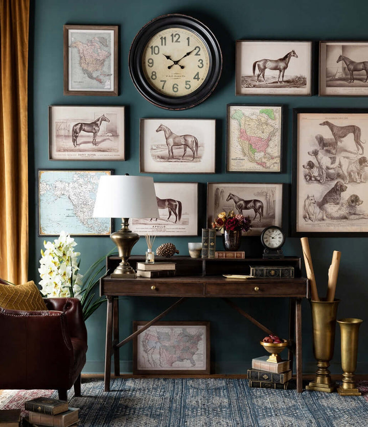 Vintage-inspired study with framed antique maps and horse illustrations on teal wall, vintage clock, and rustic desk.