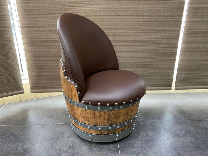 Vintage Whiskey Barrel Chair with leather cushion and rivet details in a rustic design, perfect for farmhouse decor.