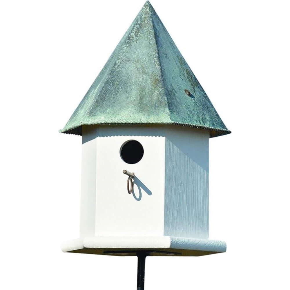 Vintage White Octagonal Bird House with Copper Roof against blue sky, fairy-tale design for gardens, inviting to bluebirds.