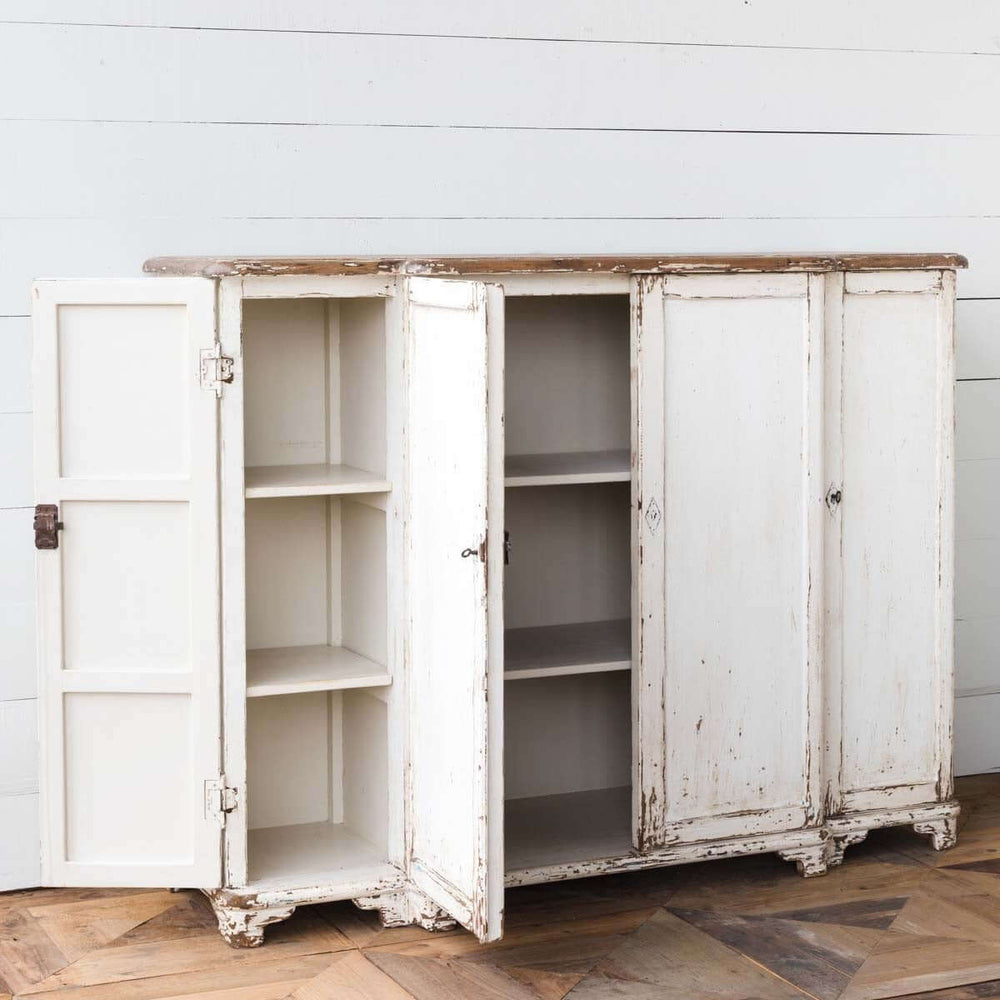 Vintage white entryway cabinet with distressed wood top and open doors, showcasing interior shelves against a rustic backdrop.