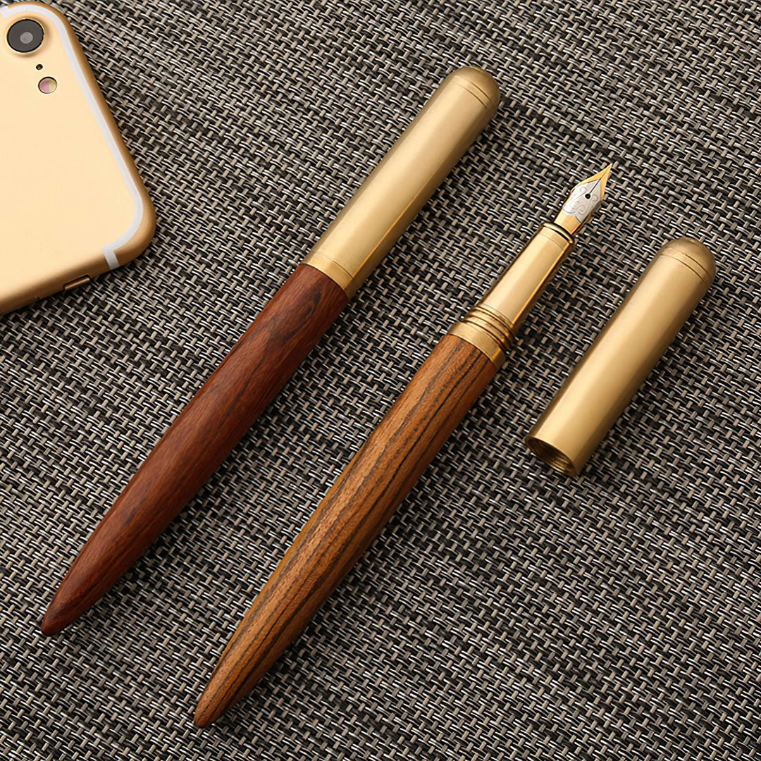 Vintage Wood and Brass Fountain Pen | The Hemmingway displayed on a textured surface, showcasing its elegant wooden and brass design.