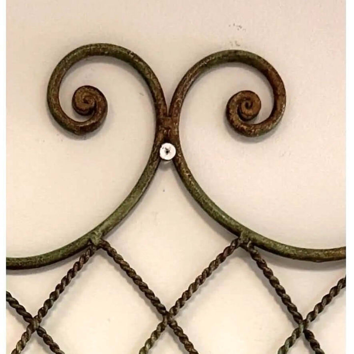 Close-up of Vintage Wrought Iron Wall Basket Planter with Scrollwork Design featuring elegant curves and rustic detailing.