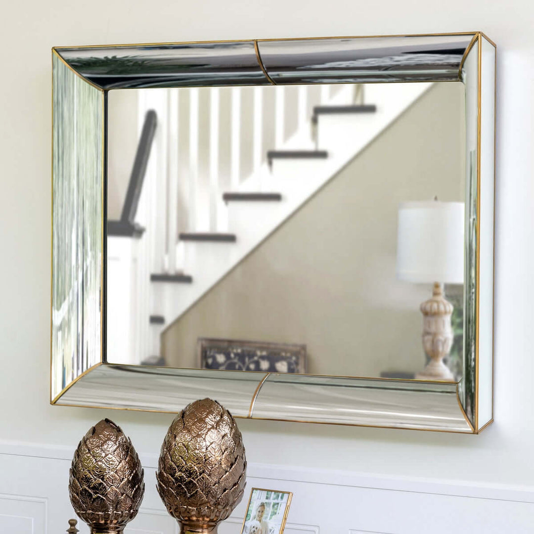 Vintage Beveled Wall Mirror with Gold Trim hanging in hallway, reflecting staircase and lamp.