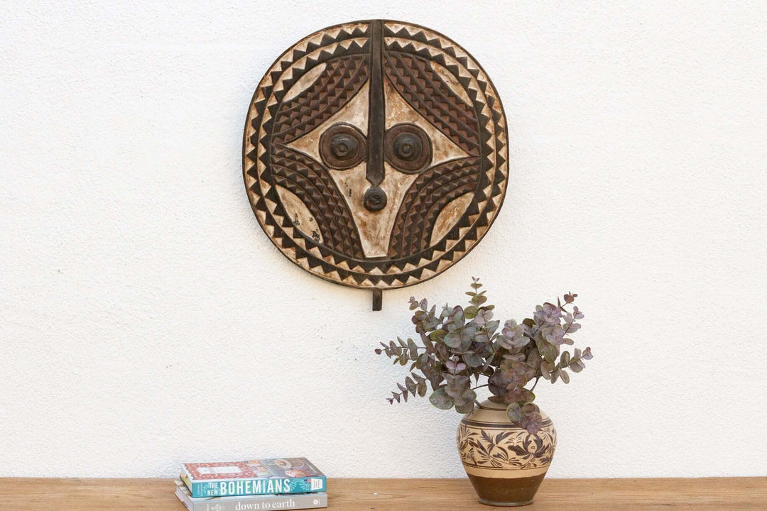 Vintage Bobo African Sun Mask from Burkina Faso displayed on wall, showcasing intricate hand-carved wooden design and symbolic artistry.