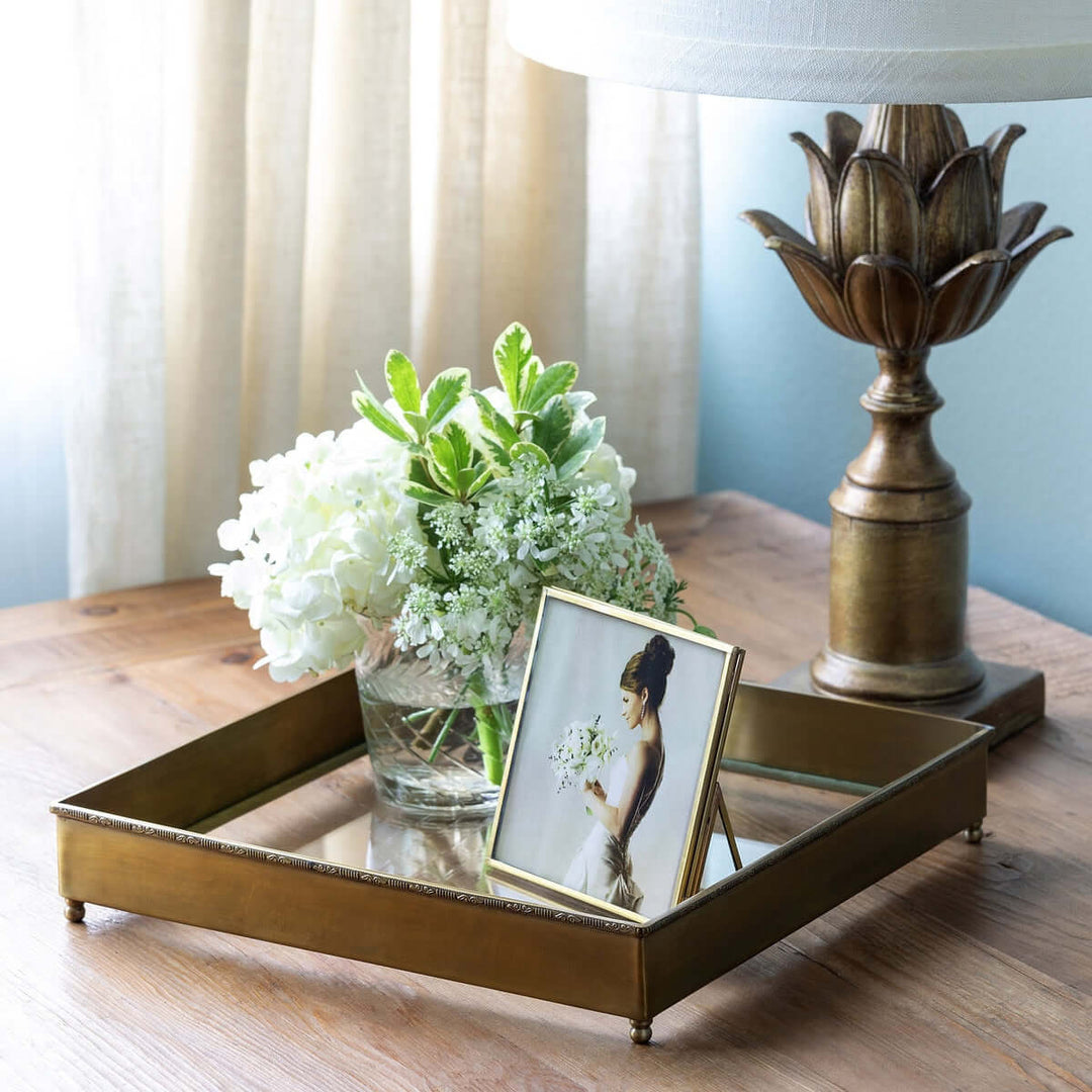 Elegant Vintage Brass and Glass Desk Tray on wooden table with decorative items, including a flower vase and photo frame.