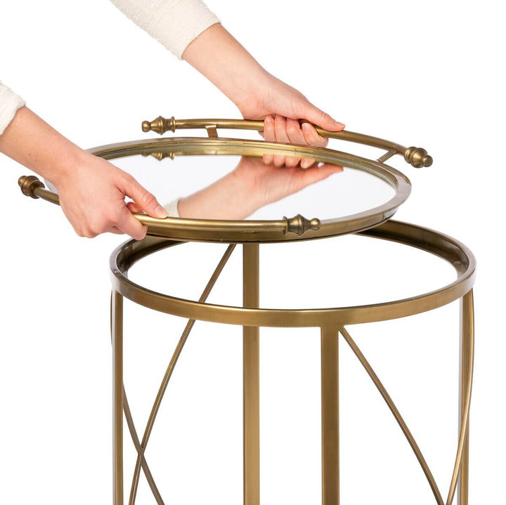 Hands assembling vintage brass bar cart with mirrored shelves
