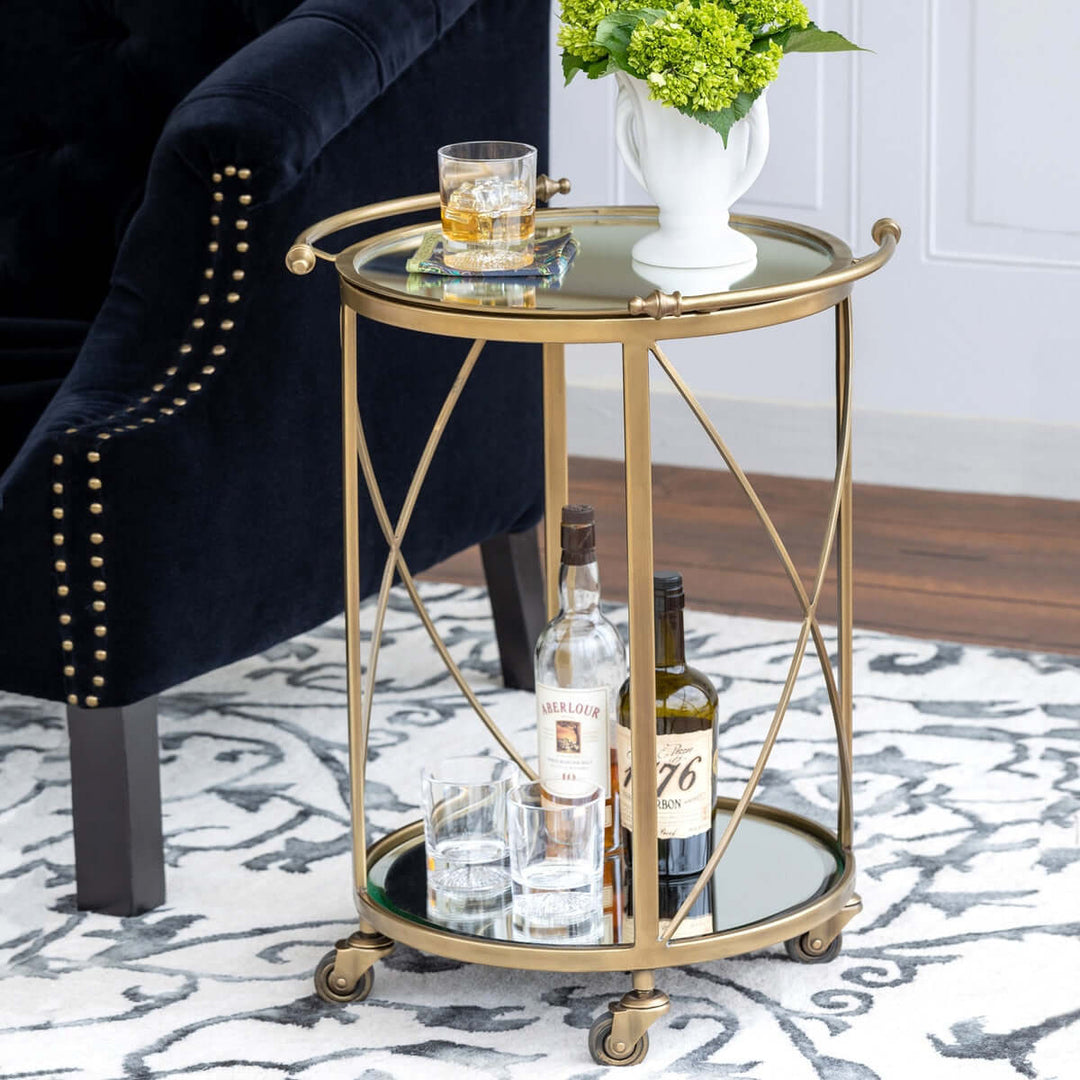 Vintage brass round bar cart with mirrored shelves, featuring elegant brass frame and stylish Hollywood Regency design.
