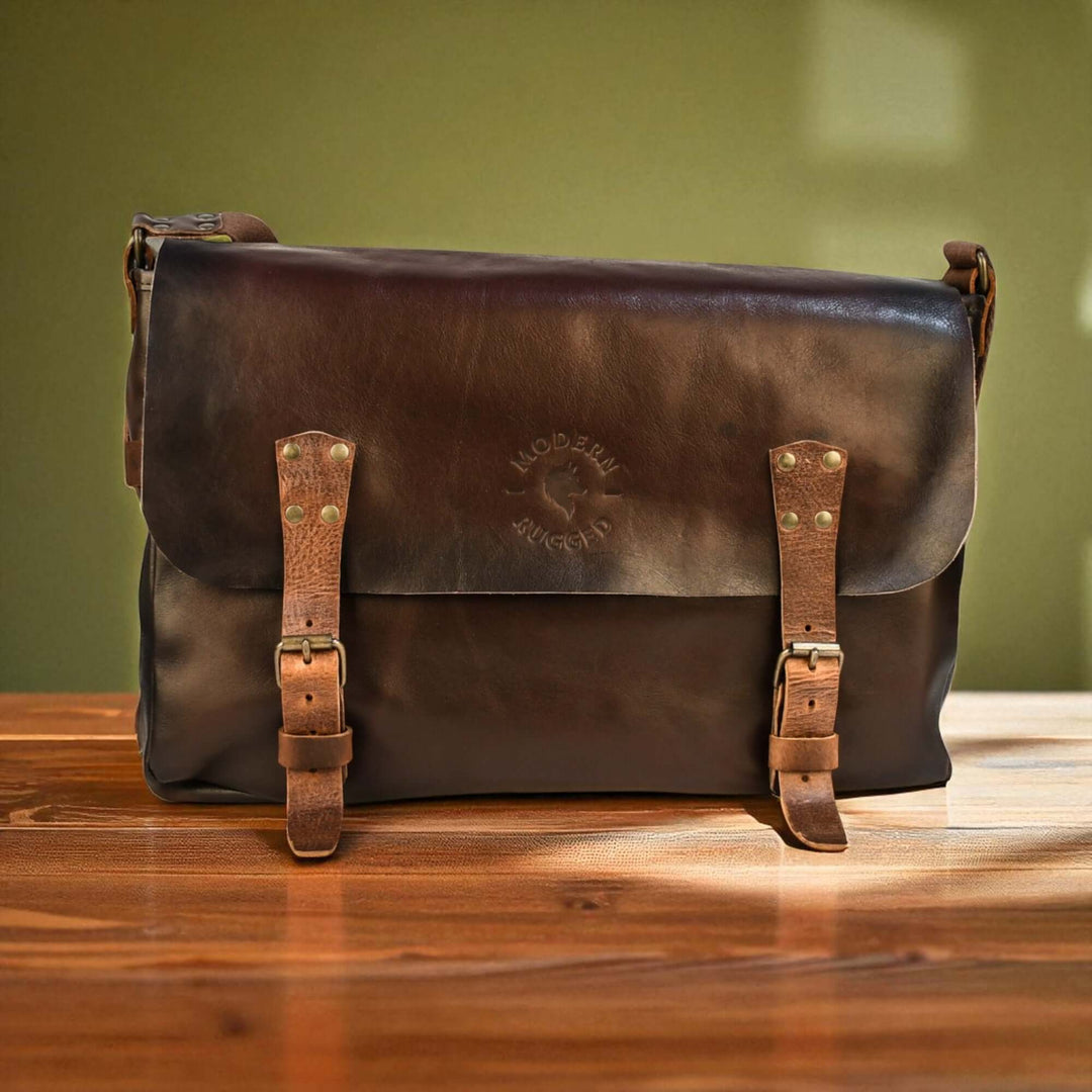 Vintage Brown Leather Messenger Bag on wooden table, showcasing rich craftsmanship and classic buckled straps for timeless appeal.
