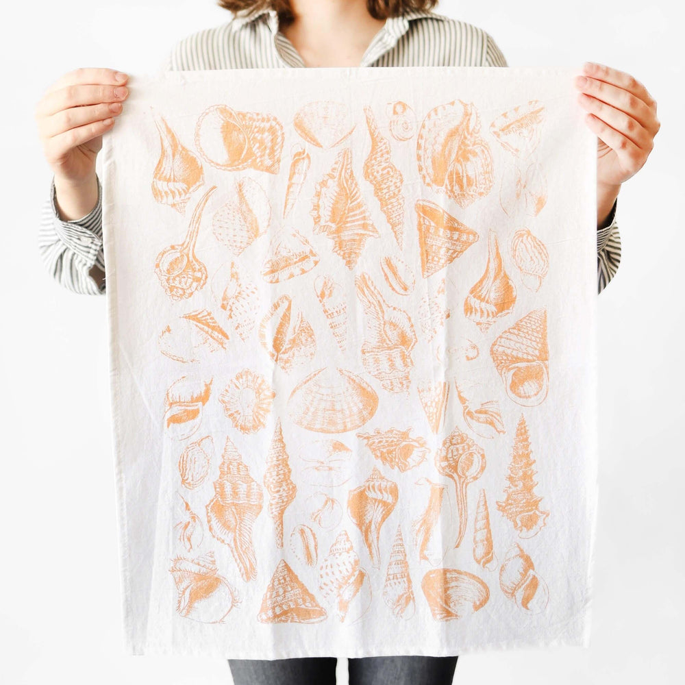 Alt Tag: Person holding Vintage Coastal Seashell Tea Towel with watercolor-style seashell design, evoking seaside serenity.