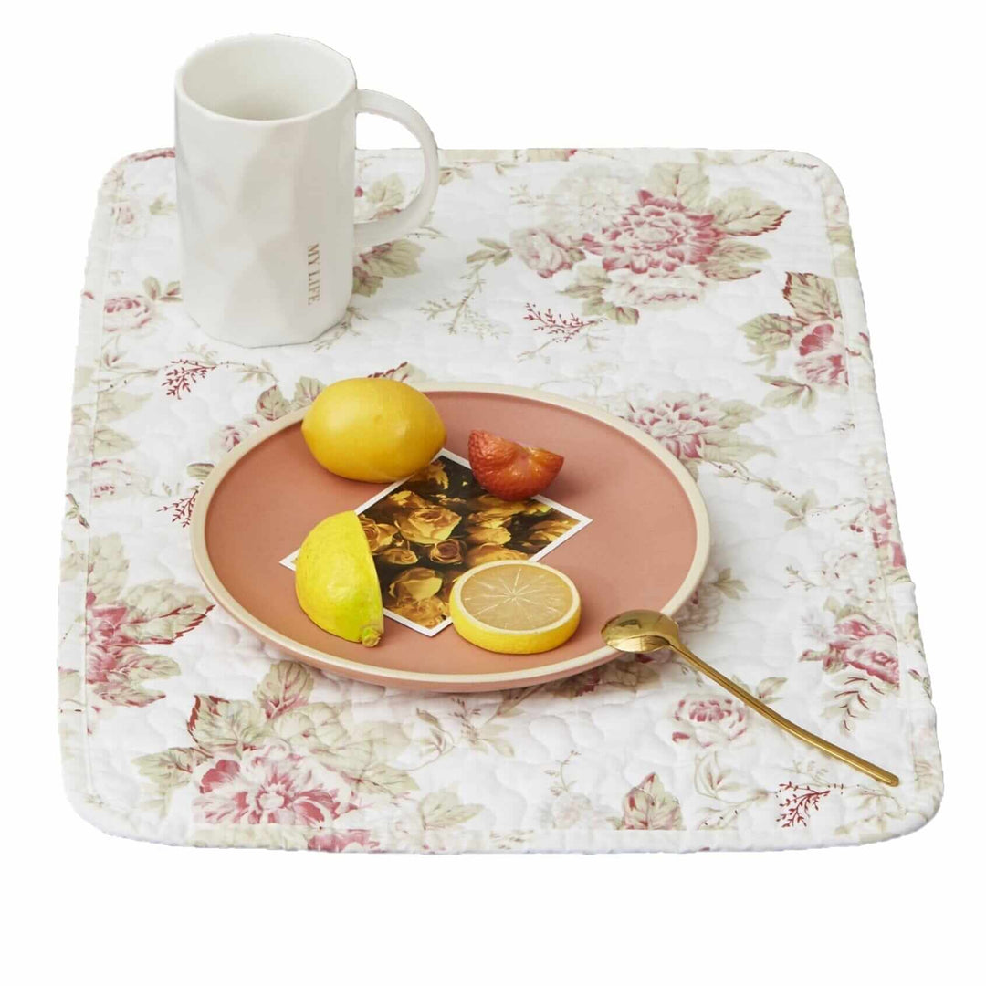 Vintage Cottage Rose Quilted Placemats (Set of 4) featuring pink roses and green leaves with breakfast plate and mug on table