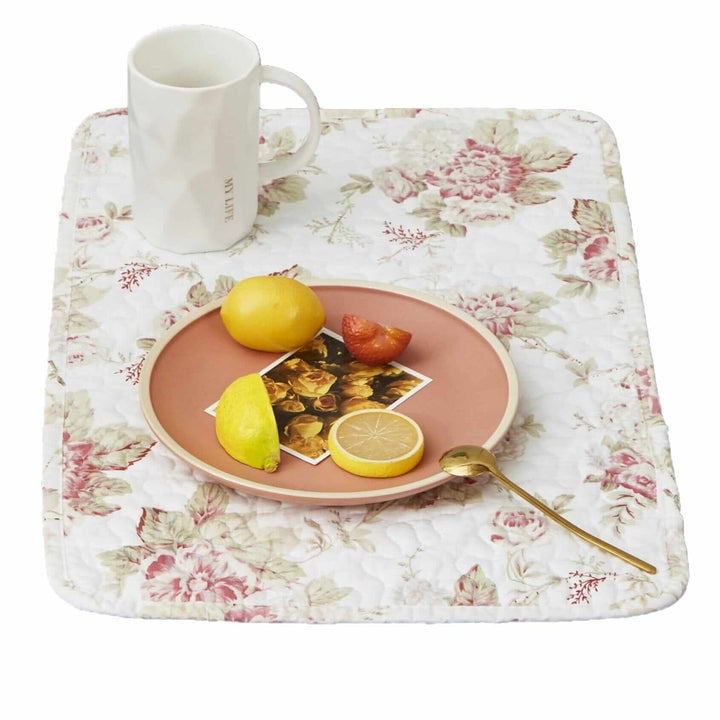 Vintage Cottage Rose Quilted Placemats (Set of 4) featuring pink roses and green leaves with breakfast plate and mug on table