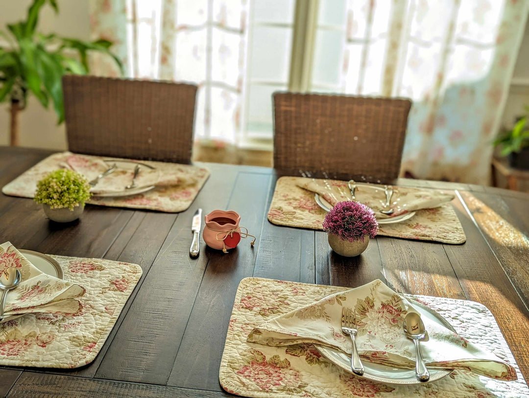 Vintage Cottage Rose Quilted Placemats (Set of 4) on rustic dining table with floral design and cutlery, adding romantic farmhouse charm.