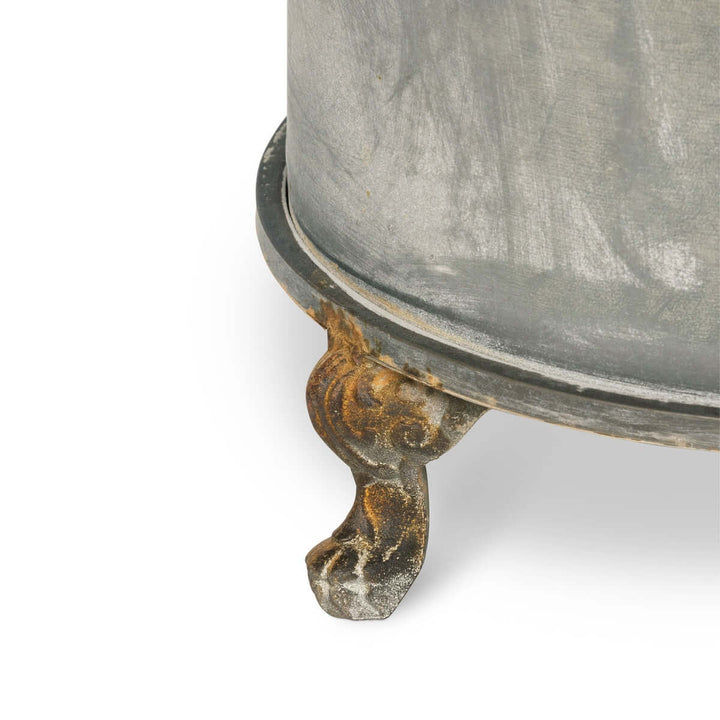 Close-up of the Vintage Creamery Tank Footed Planter showcasing one of its intricately detailed rust patina iron feet.