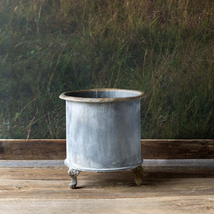 Vintage Creamery Tank Footed Planter with rustic iron finish and scrolled feet, inspired by early 20th-century dairy farms.