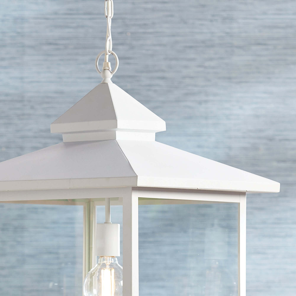 White vintage farmhouse hanging lantern light with clear glass panes, evoking rustic charm and nostalgia for simpler times.