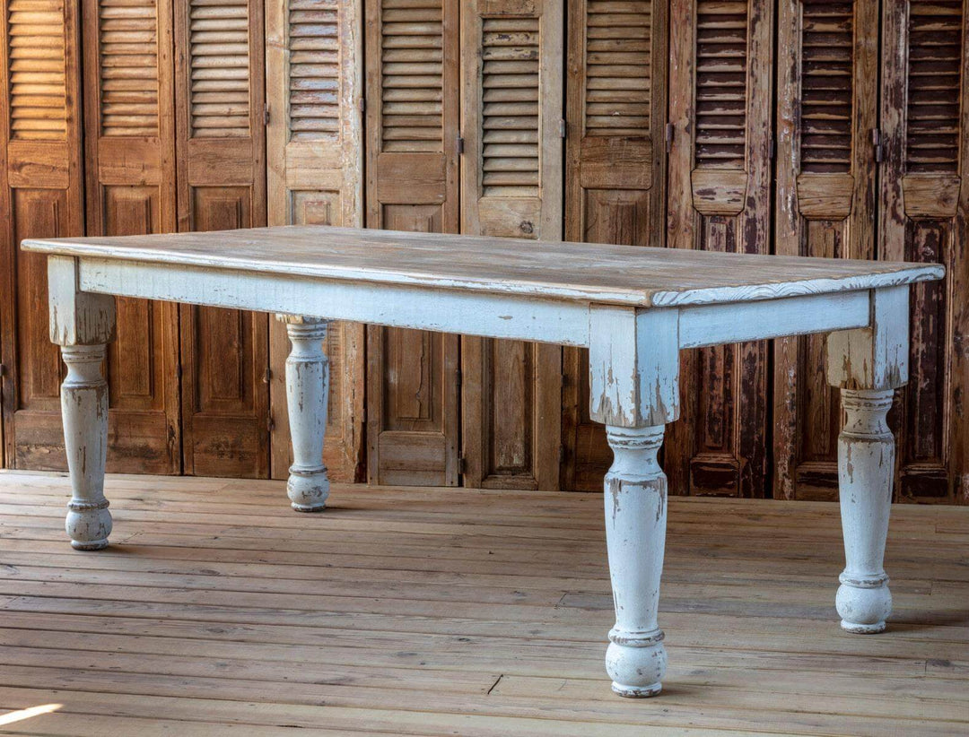 Vintage Farmhouse Harvest Dining Table in Antique White with distressed finish and hand-turned legs in rustic setting