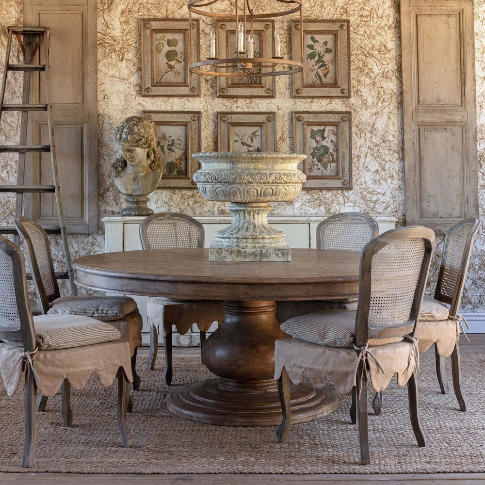 Vintage Farmhouse Round Dining Table with chairs in rustic decor setting, featuring a wooden pedestal base and classic design.