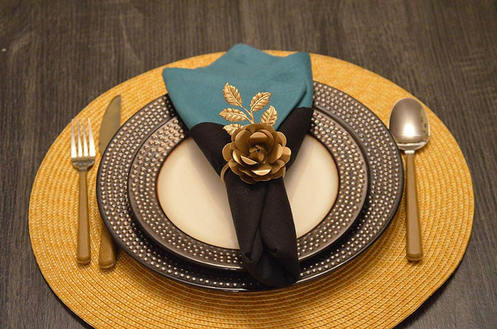 Vintage-Inspired Floral Golden Rose Napkin Rings (Set of 4) on elegant table setting with teal napkin and gold cutlery.