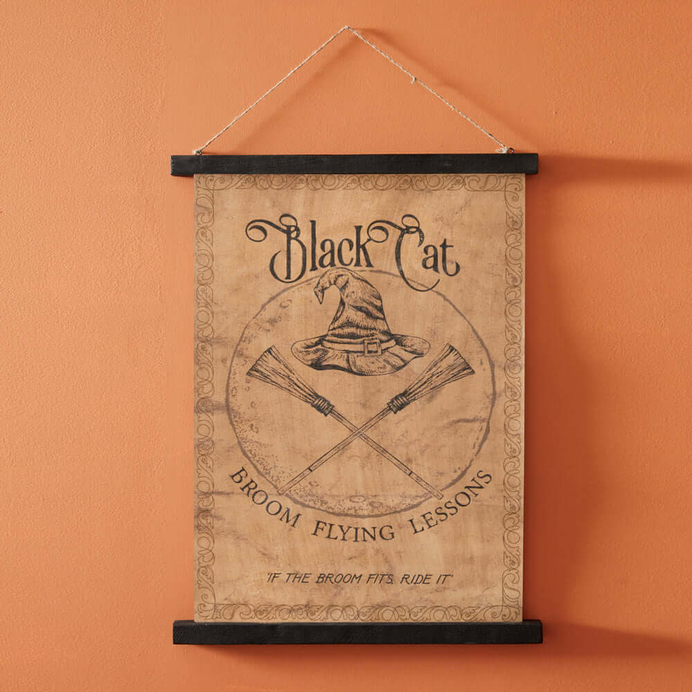 Vintage Halloween Black Cat Broom Flying Lessons wall art with witch hat and crossed brooms on parchment background.