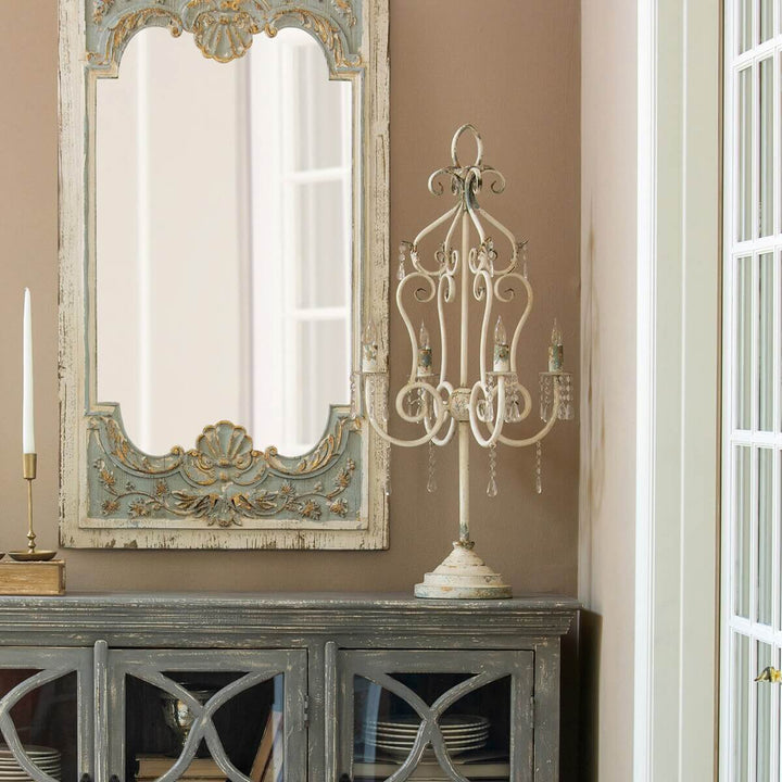 Vintage tabletop chandelier with crystals adds elegance, featuring distressed finish, antique styling, and ornate curves on a sturdy base.
