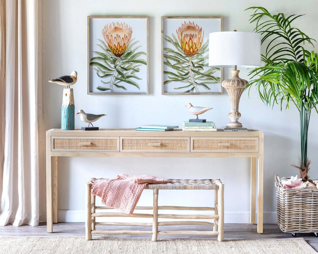 Vintage teak and rattan entryway bench in a cozy living room setting with decor and wall art.
