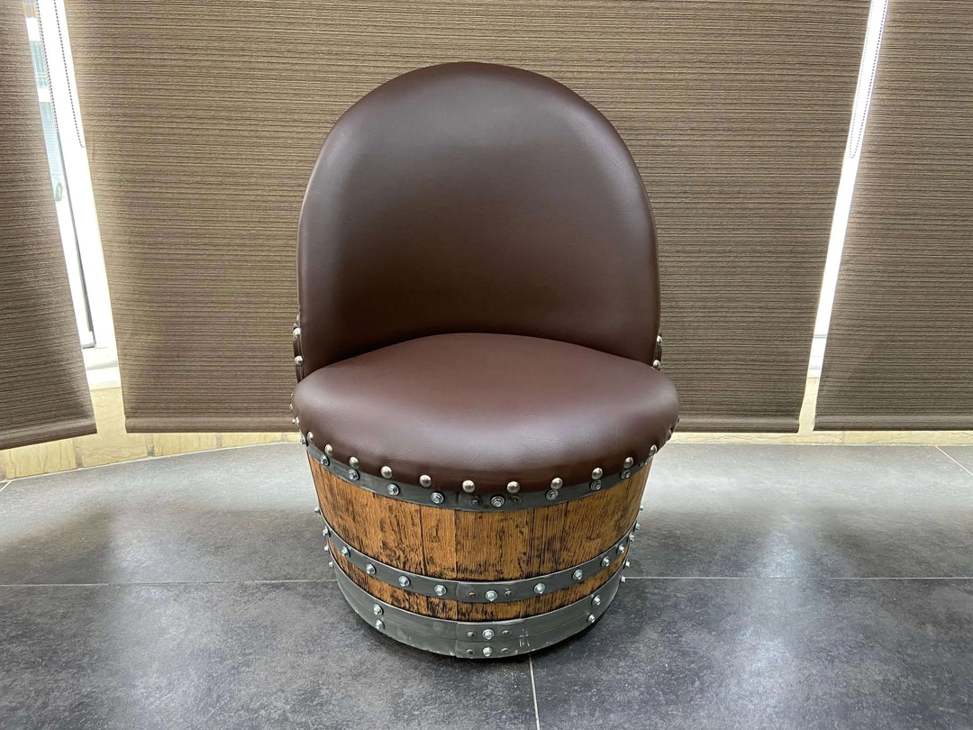 Vintage Whiskey Barrel Chair with brown leather seating on casters, showcasing handcrafted design and hidden compartment feature.