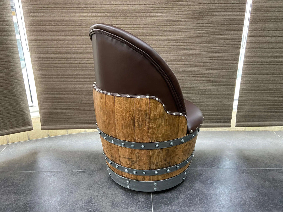 Side view of a Vintage Whiskey Barrel Chair with a wooden barrel design and leather upholstery, showcasing its rustic charm.