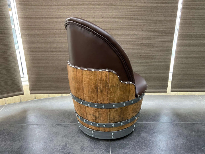 Side view of a Vintage Whiskey Barrel Chair with a wooden barrel design and leather upholstery, showcasing its rustic charm.