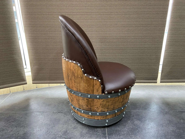 Side view of a Vintage Whiskey Barrel Chair with leather upholstery and metal accents, showcasing its handcrafted design on casters.