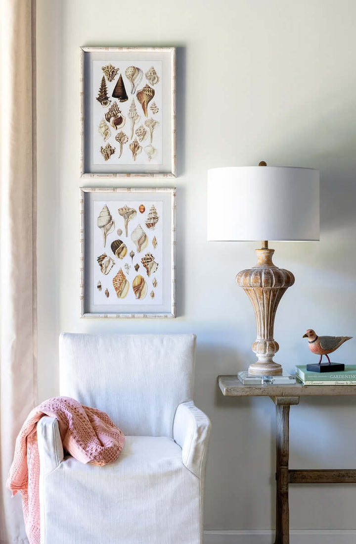 Vintage whitewashed urn table lamp with crystal base, linen shade, beside a cozy chair and art, in a tranquil, elegant setting.
