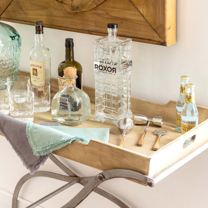 Vintage Wooden Tray Console Table styled as a bar with bottles, glasses, and garnishes, showcasing rustic elegance and practicality.