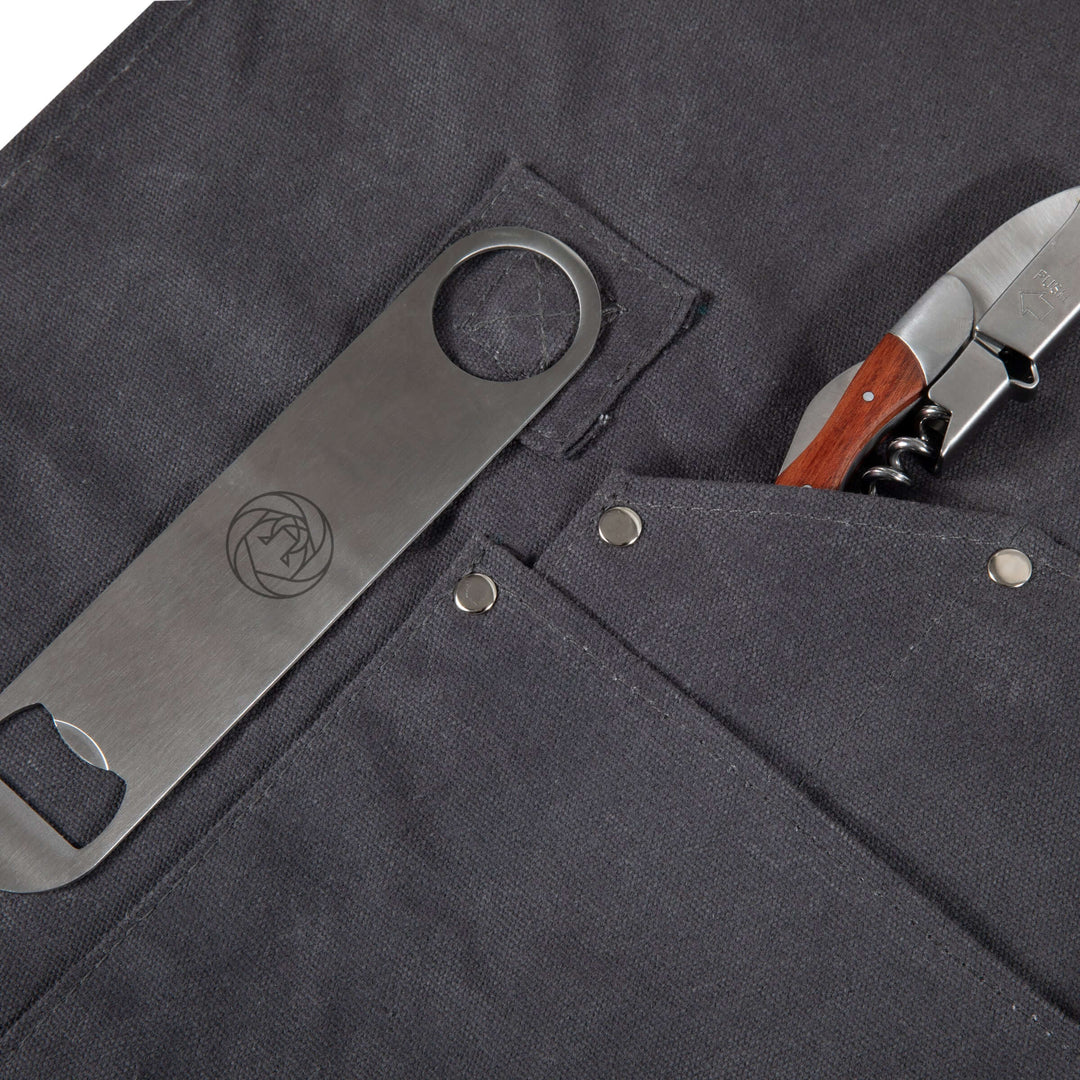 Close-up of Waxed Canvas Bartender Apron and Tools, featuring durable pockets with bottle opener and knife, ideal for professional mixology.