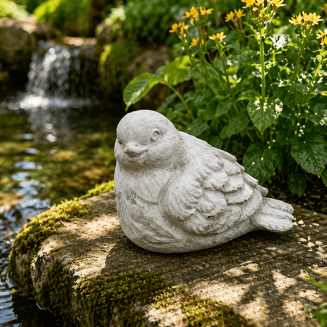 Rounded Weathered Cement Bird Garden Statue on a mossy ledge