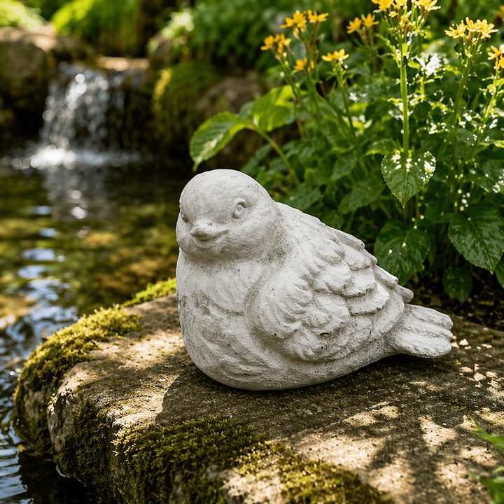 Rounded Weathered Cement Bird Garden Statue on a mossy ledge