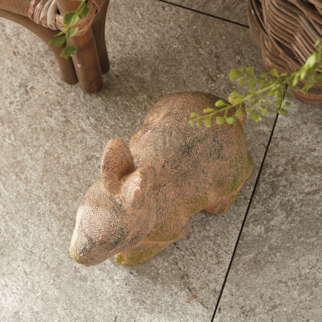 Weathered moss terracotta bunny garden statue, adding vintage charm to outdoor decor with natural textures.