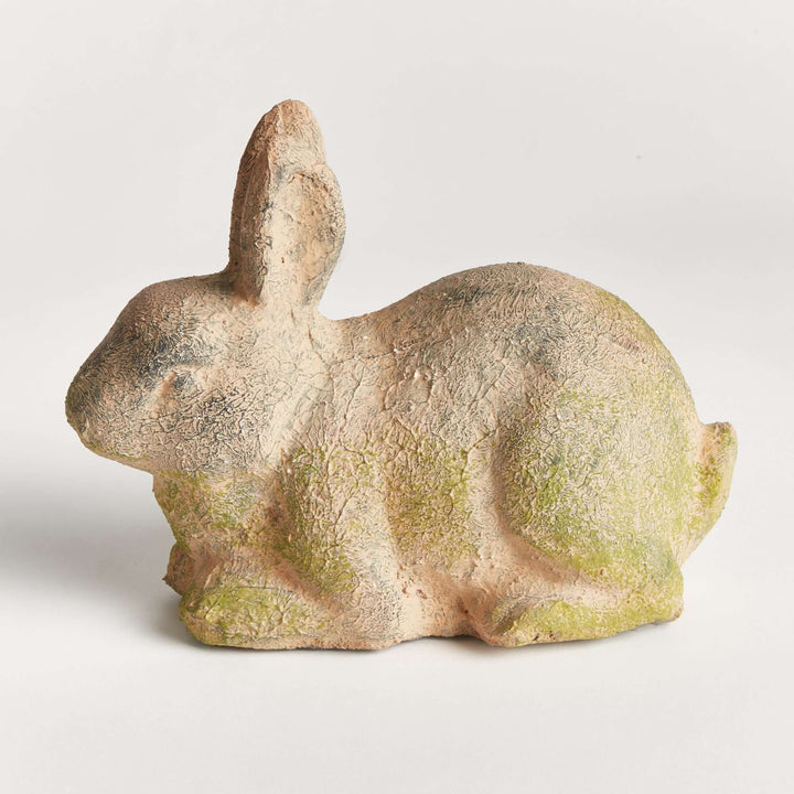 Weathered moss terracotta bunny garden statue, showcasing vintage charm and natural texture in a beautiful outdoor decor piece.