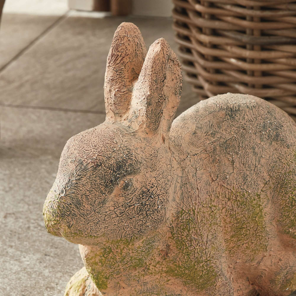 Weathered moss terracotta bunny garden statue showcasing vintage charm and natural textures for outdoor decor.