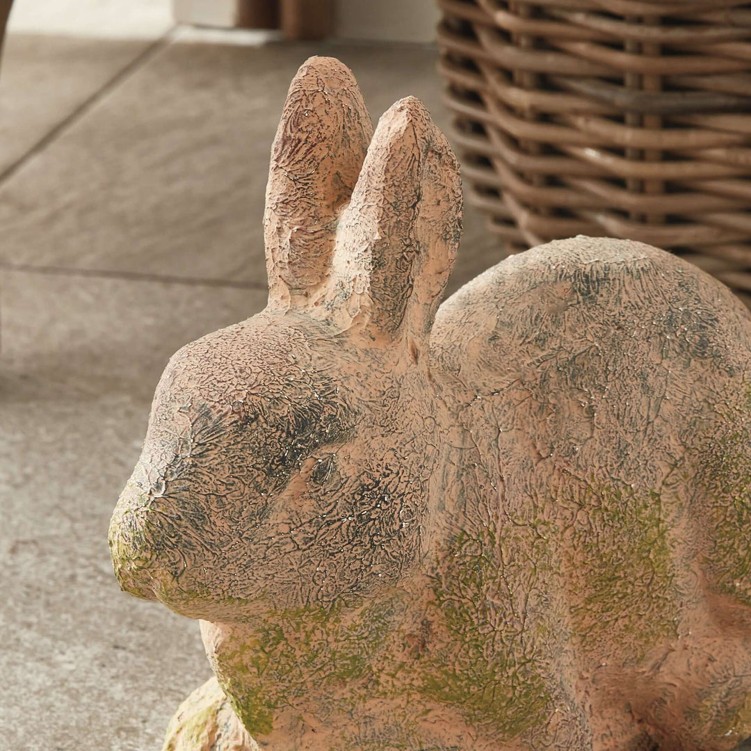 Weathered moss terracotta bunny garden statue showcasing vintage charm and natural textures for outdoor decor.